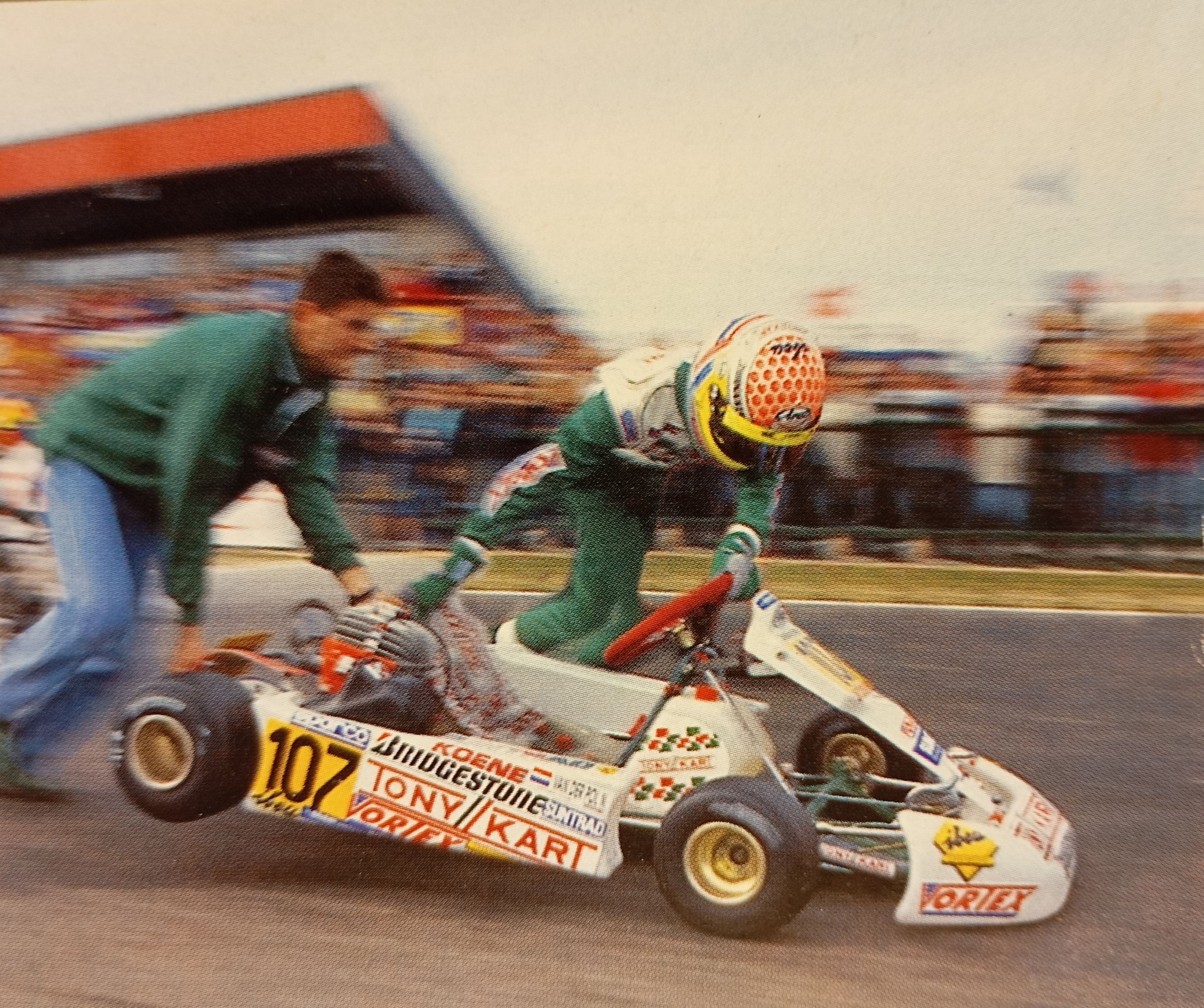 Tony Kart #107 driver being pushed off the grid by mechanic