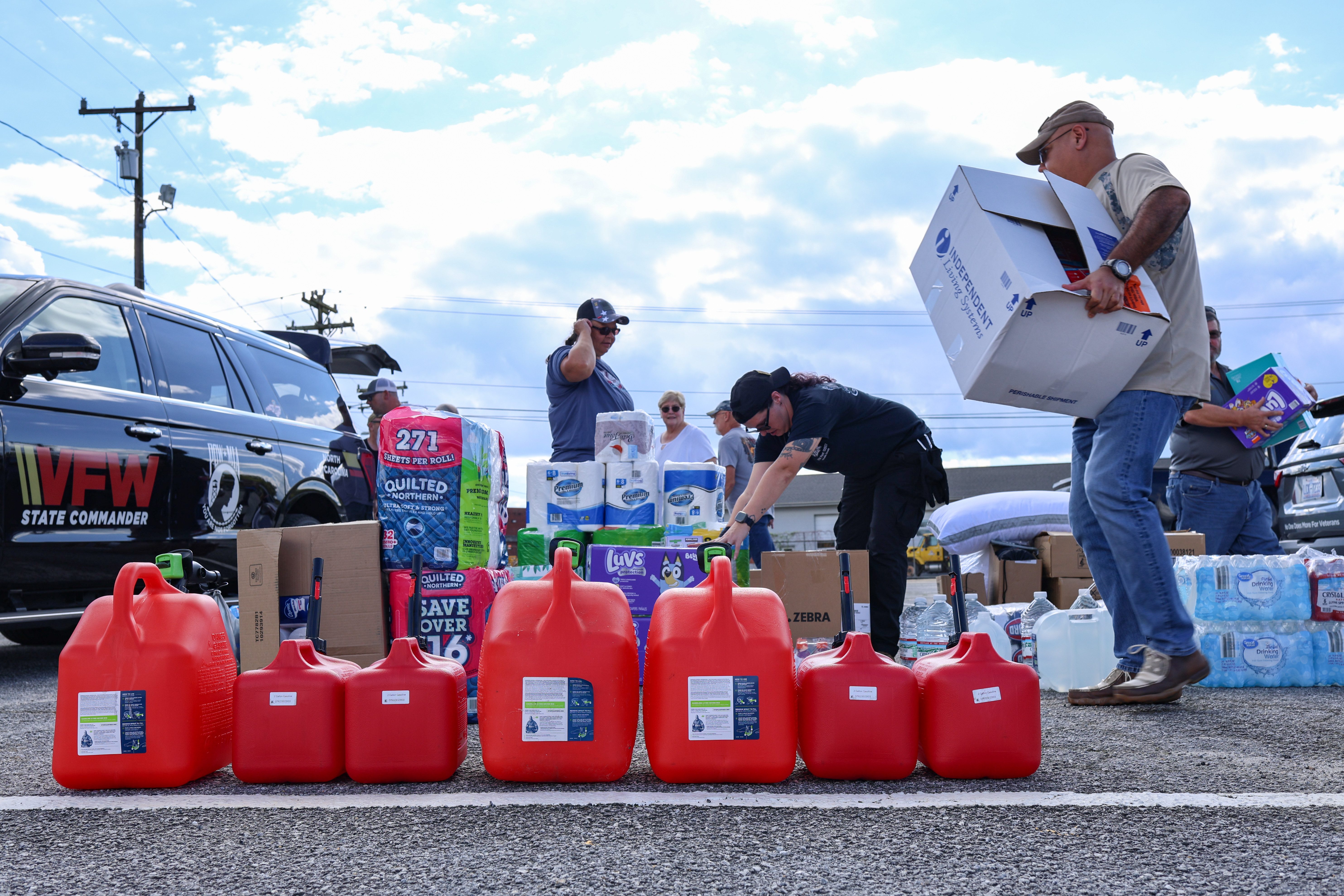 VFW disaster relief supply distribution with volunteers, gas cans, and State Commander vehicle