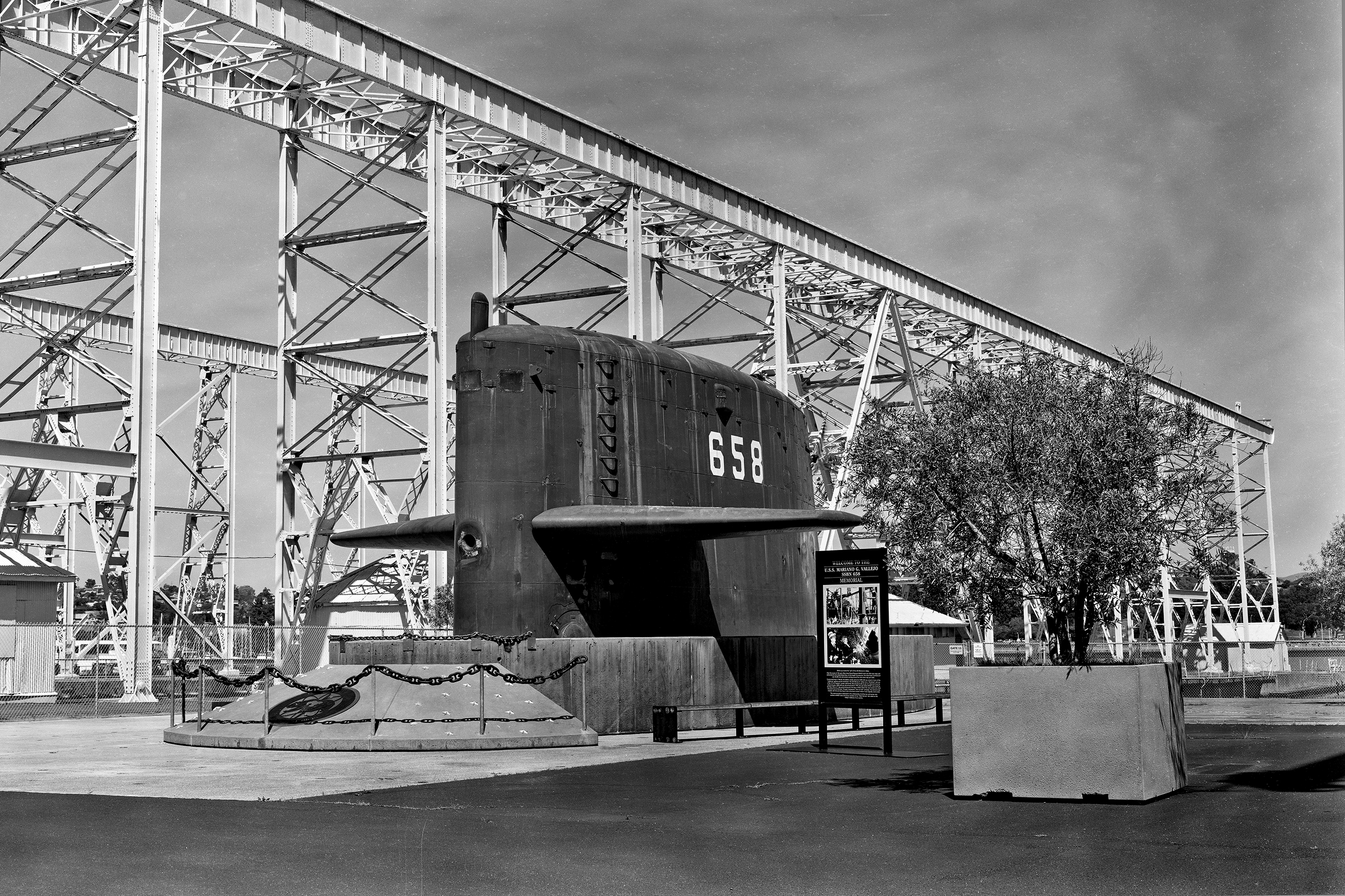 USS Mariano G Vallejo SSBN-658 submarine sail displayed under large steel crane structure framework with informational placard