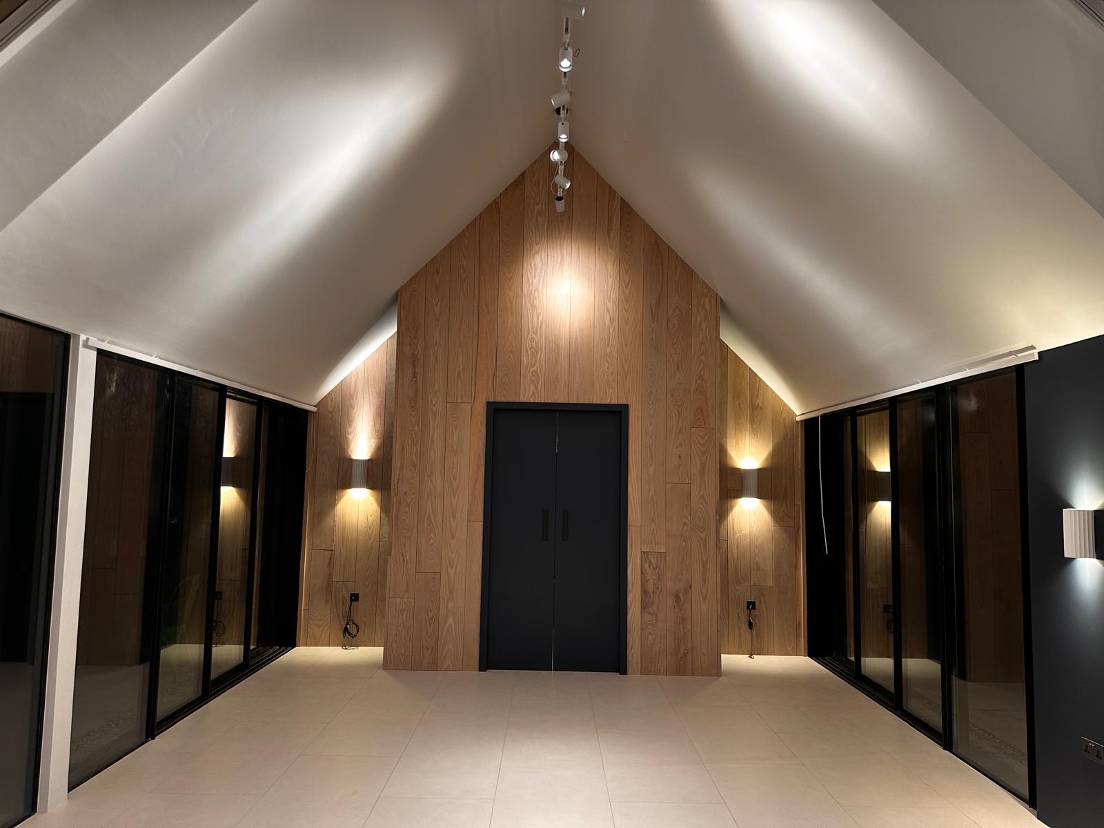 Pool house exterior at night with oak feature wall