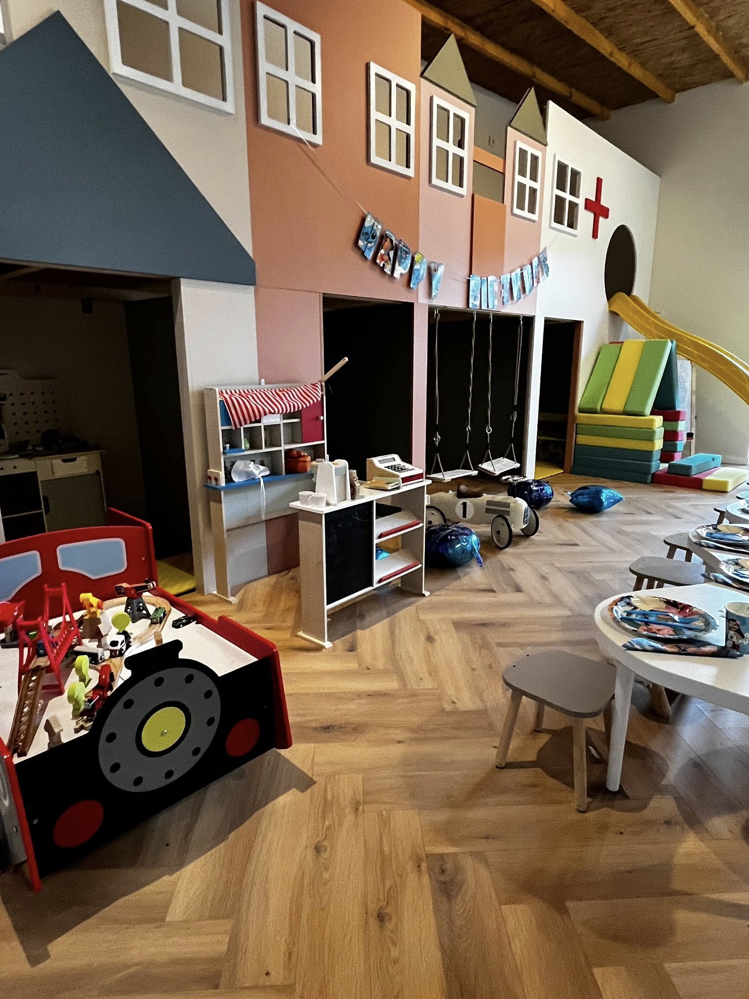 Spațiu interior Kids Club cu orășel colorat, leagăn, tobogan și jucării