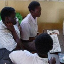 Drei Schüler arbeiten gemeinsam an einem Computer im Schulungsraum