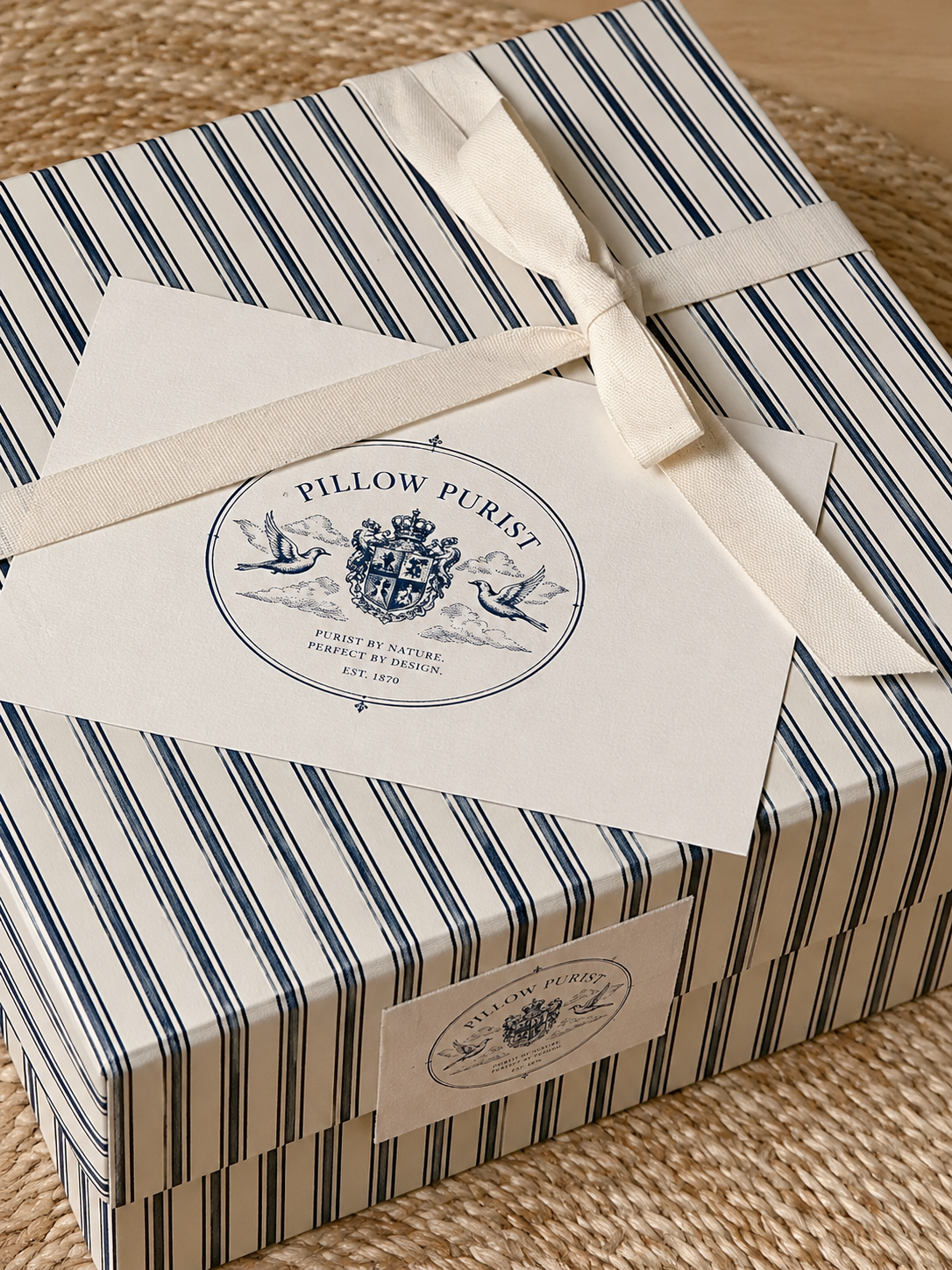 Pillow Purist gift box with navy stripe ribbon and branded crest card
