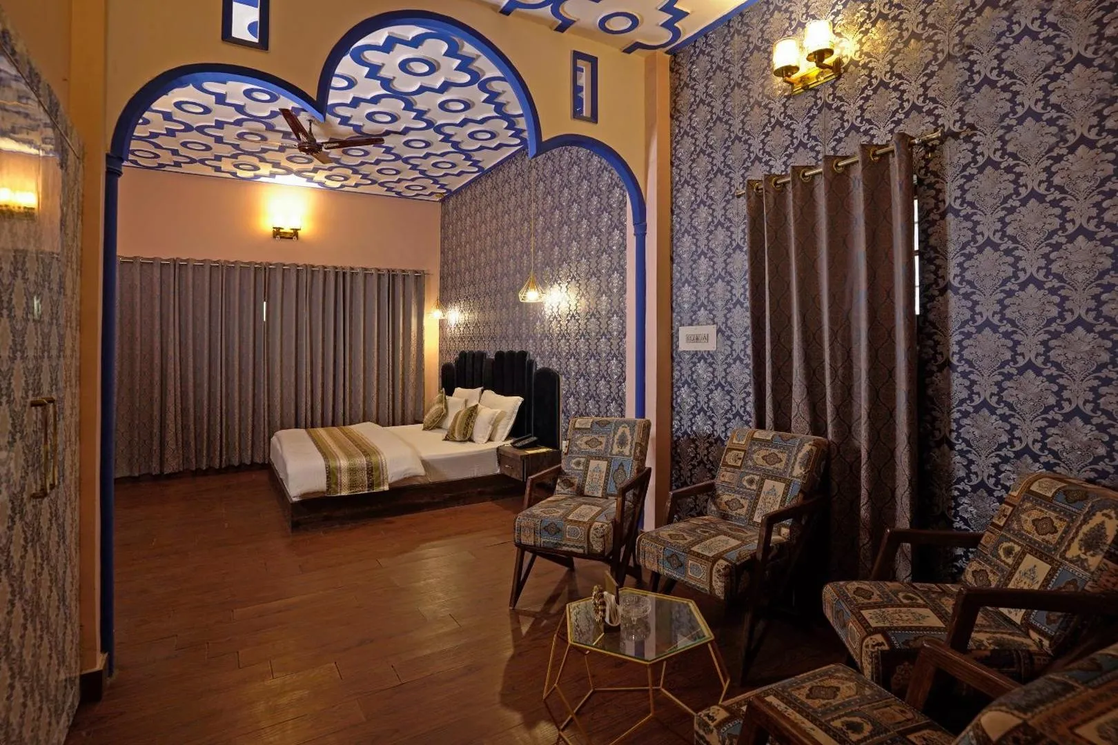 Suite with a blue arched ceiling, separate bedroom alcove, and a spacious sitting area