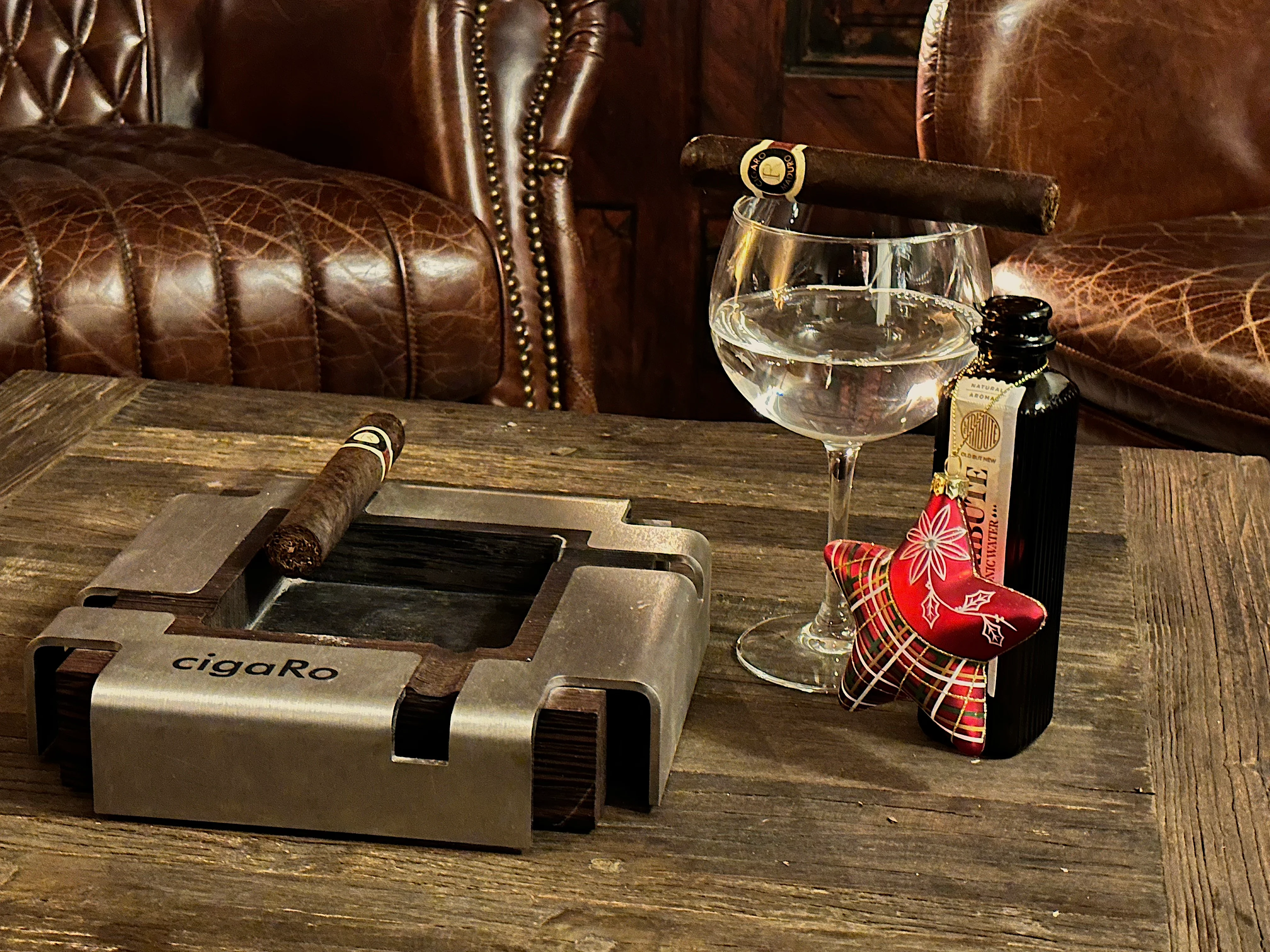 Zigarre auf einem Weinglas mit Tonic-Water-Flasche auf dem Tisch