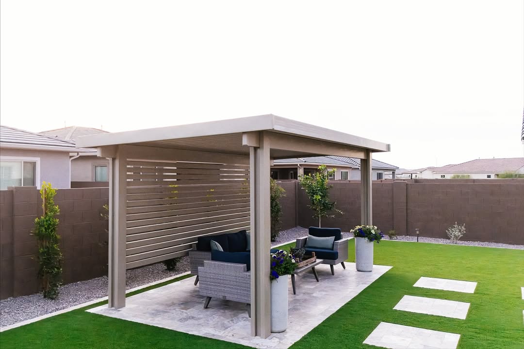 Modern pergola with louvered privacy wall, wicker seating, and travertine steppers in artificial turf