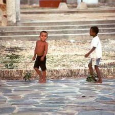 Zwei Jungen spielen barfuß auf dem Pflaster