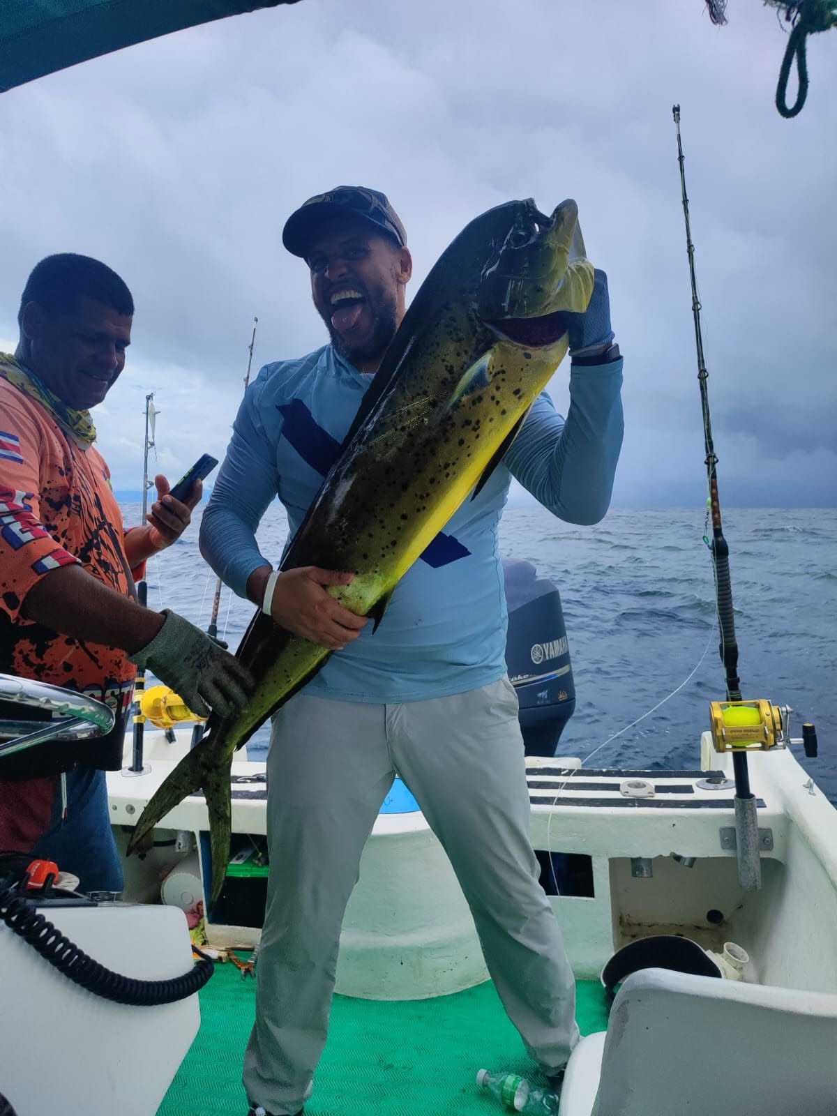 Pescador mostrando un dorado en alta mar