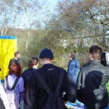 Gruppe sammelt sich vor dem gelben Container