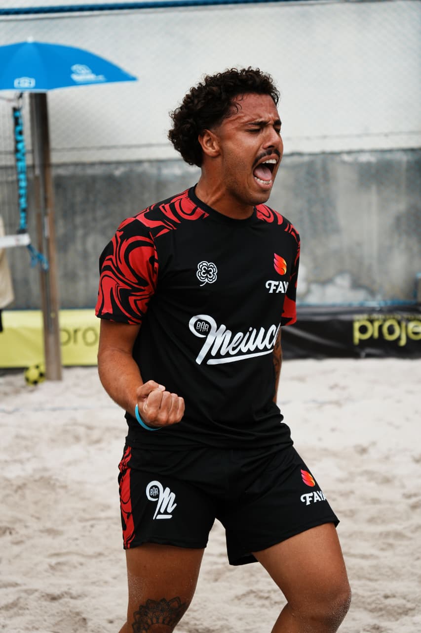 Atleta celebrando com uniforme preto e vermelho tribal — beach sports
