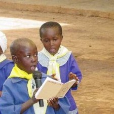 Schüler liest bei einer Schulfeier aus einem Buch vor