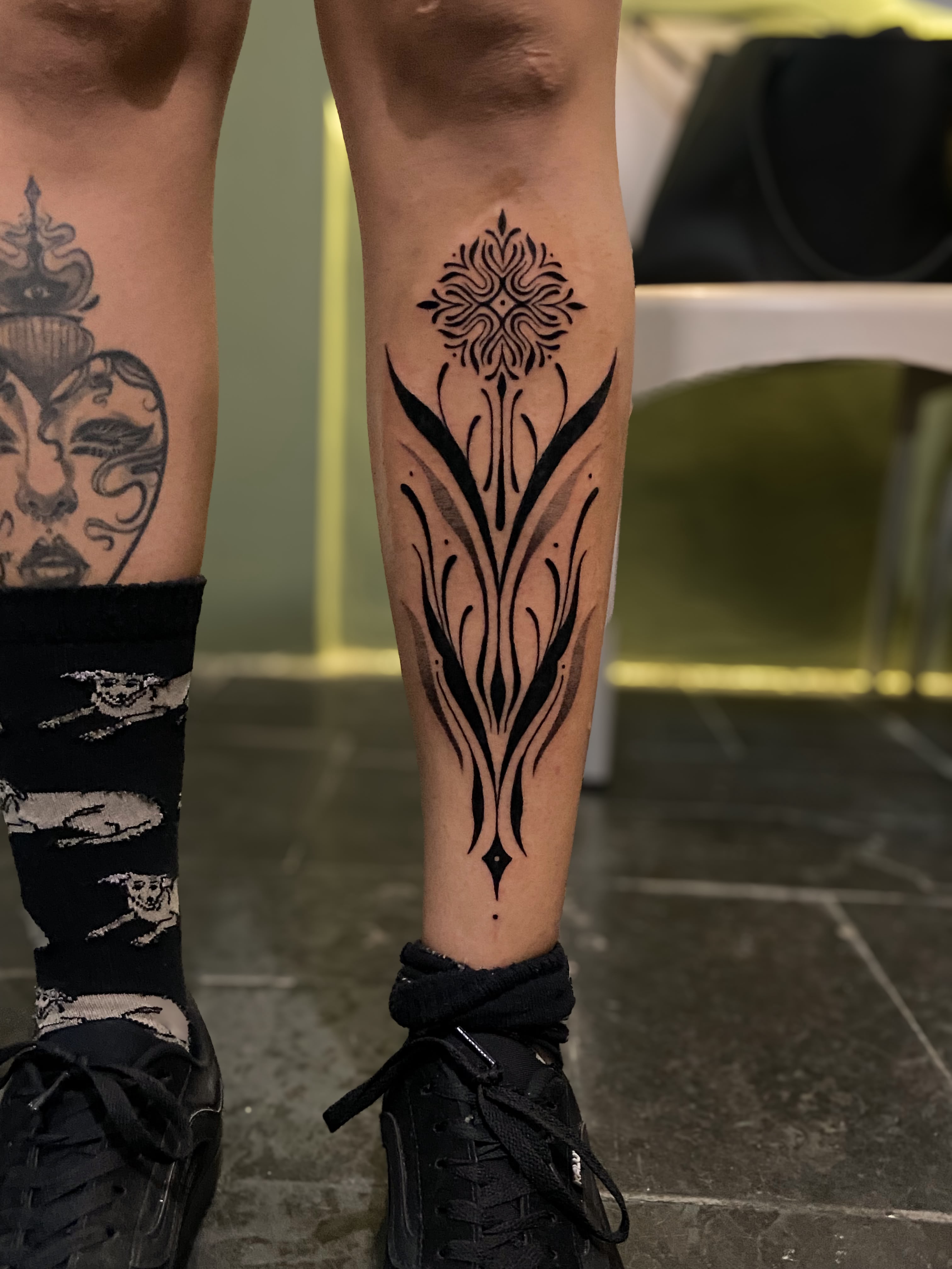Perna com tatuagem ornamental floral e mandala no topo