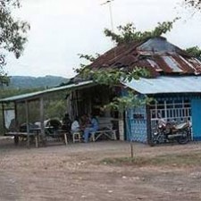 Einfaches Gebäude mit Wellblechdach und Motorrad davor