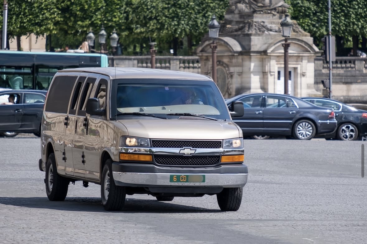 Plaque 6 CD — États-Unis, Chevrolet Express, place de la Concorde Plaque diplomatique verte 6 CD sur un Chevrolet Express beige traversant la place de la Concorde à Paris — code 6 États-Unis