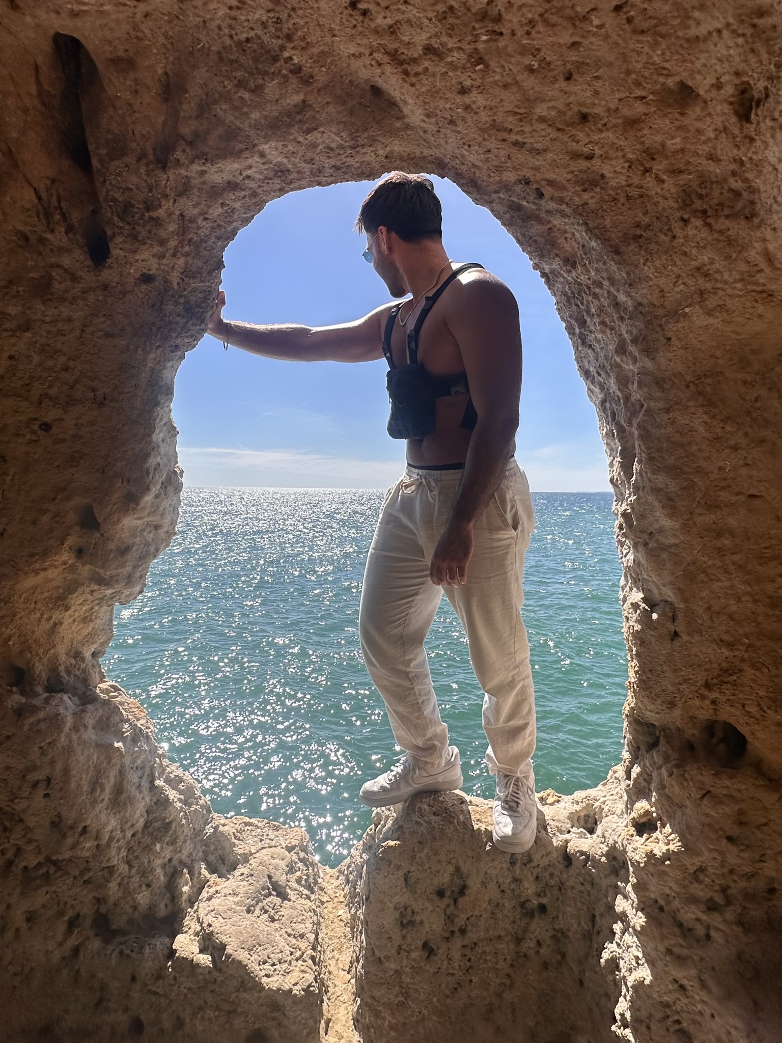 Looking out to sea through the rock arch of Gruta da Boneca