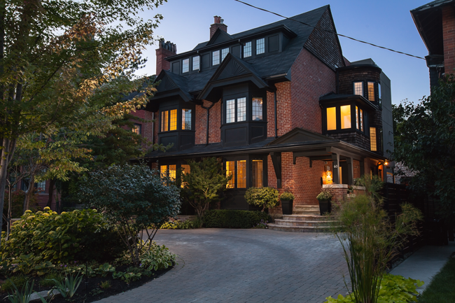 60 Bernard Avenue - Tudor-style brick house at dusk