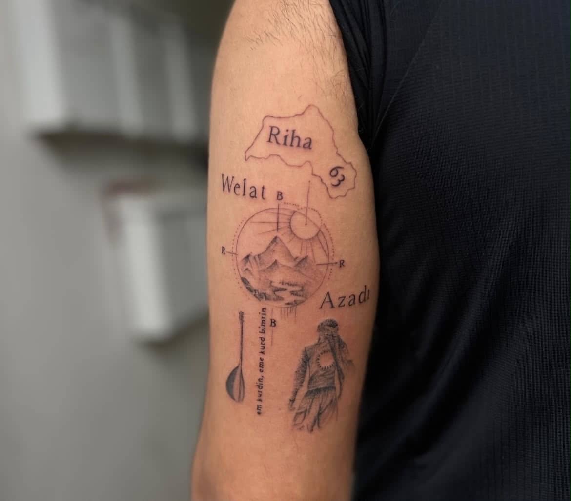 Fineline kurdisches Kultur-Tattoo mit Landkarte und Symbolen am Oberarm