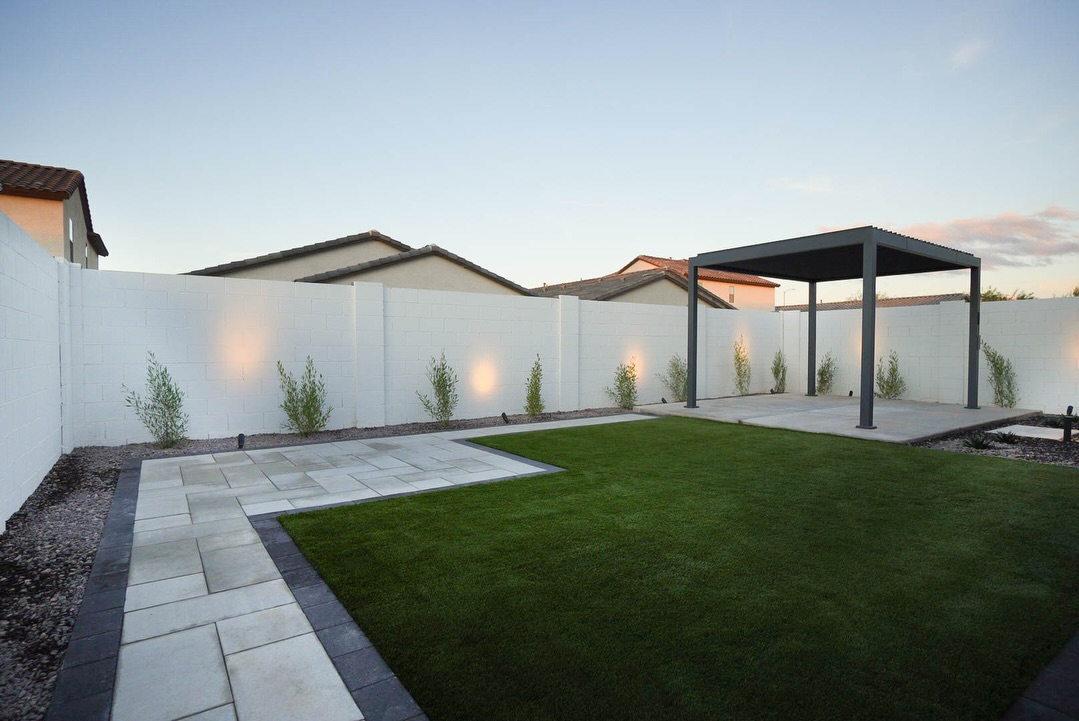 Dusk view of dark pergola with curving stepping-stone path through turf