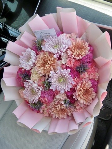Pink and cream dahlia bouquet wrapped in pink paper with Floramour Arrangements card
