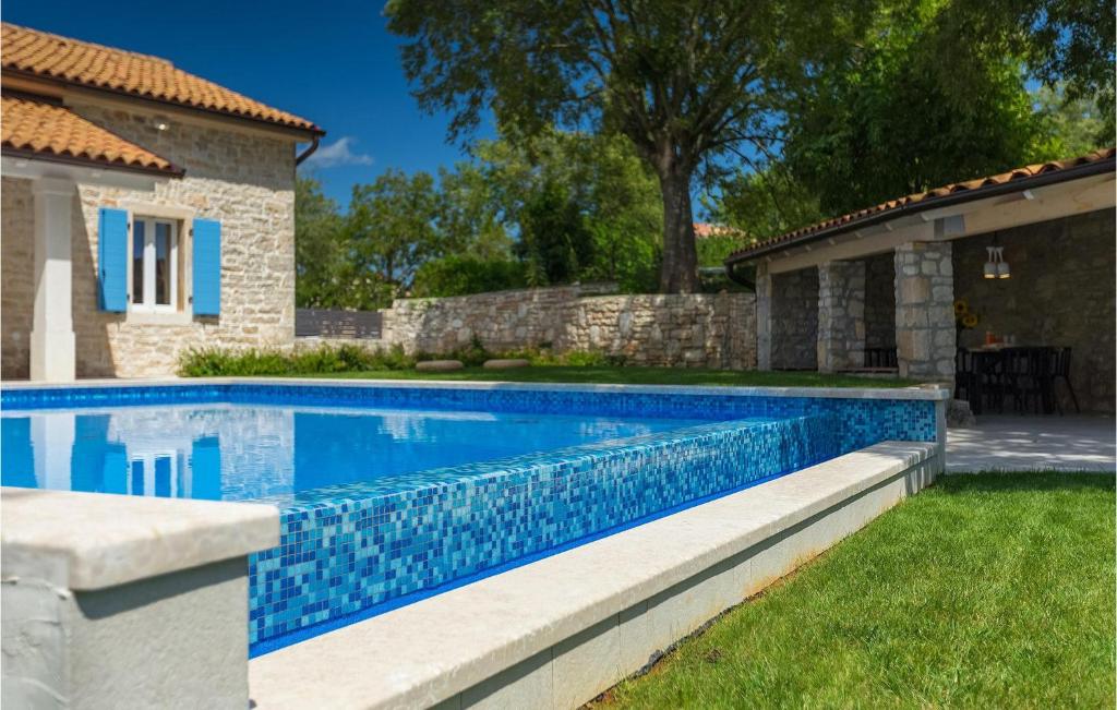 Pool with blue mosaic tiles and villa in background