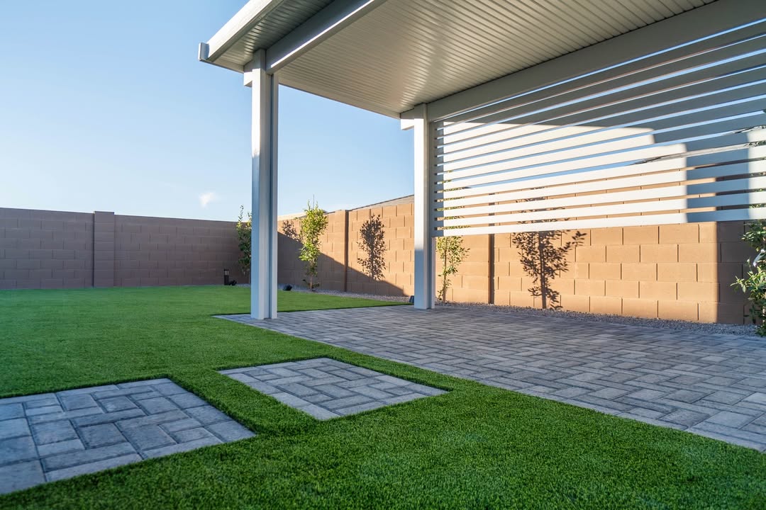White solid-roof patio cover over paver patio with turf yard