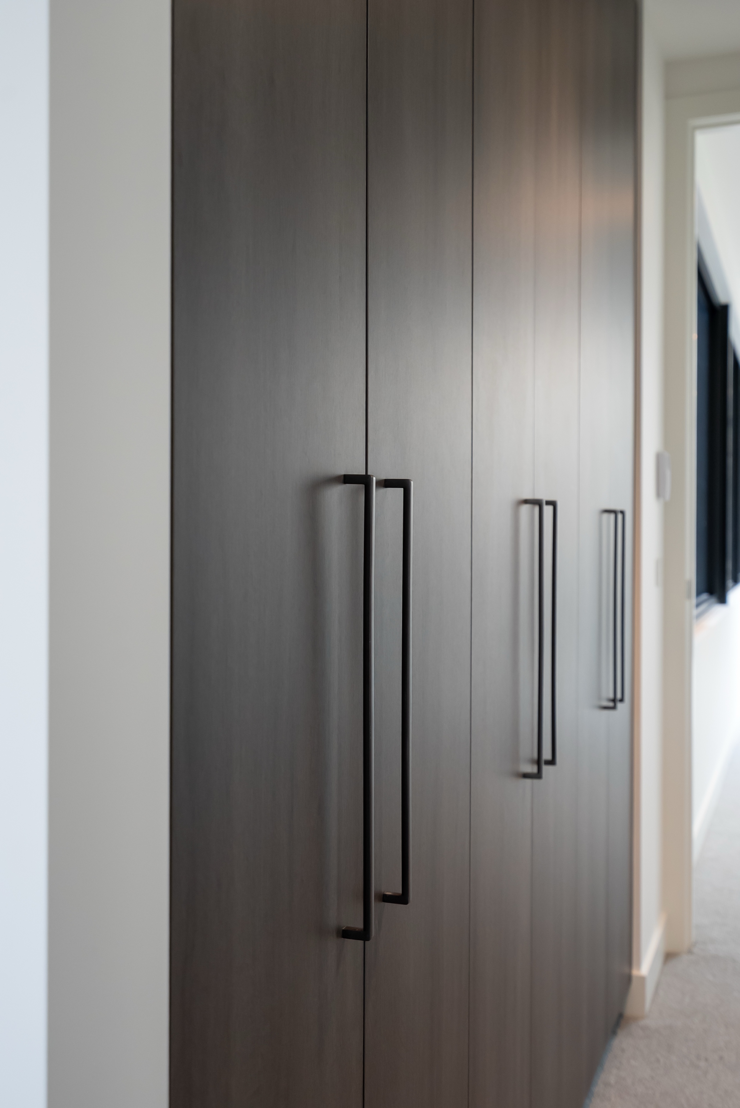 Dark timber wardrobe doors with black handles