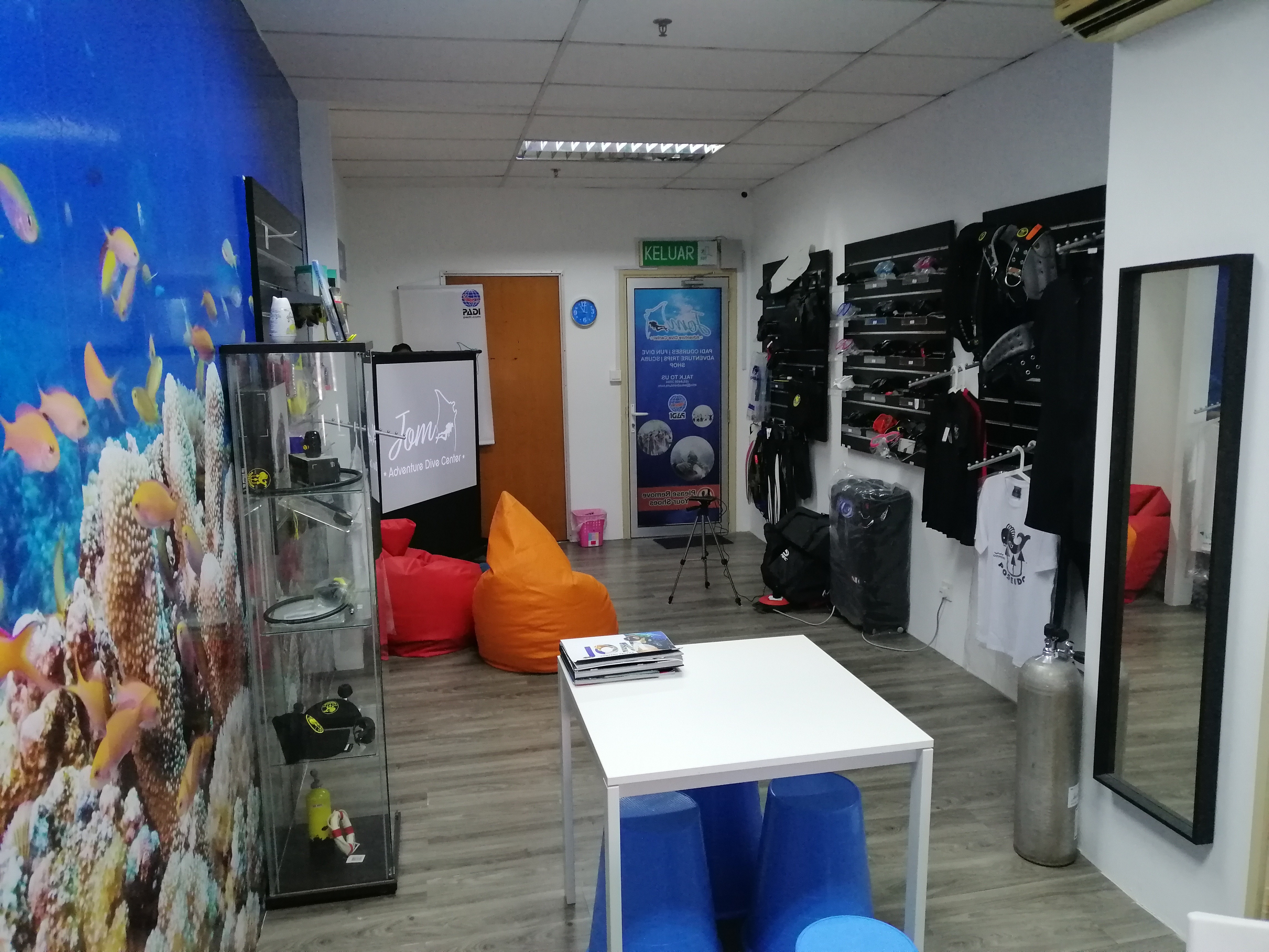 JOM Adventure Dive Centre interior with coral reef mural and dive equipment