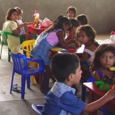 Kinder an bunten Tischen mit Spielzeug