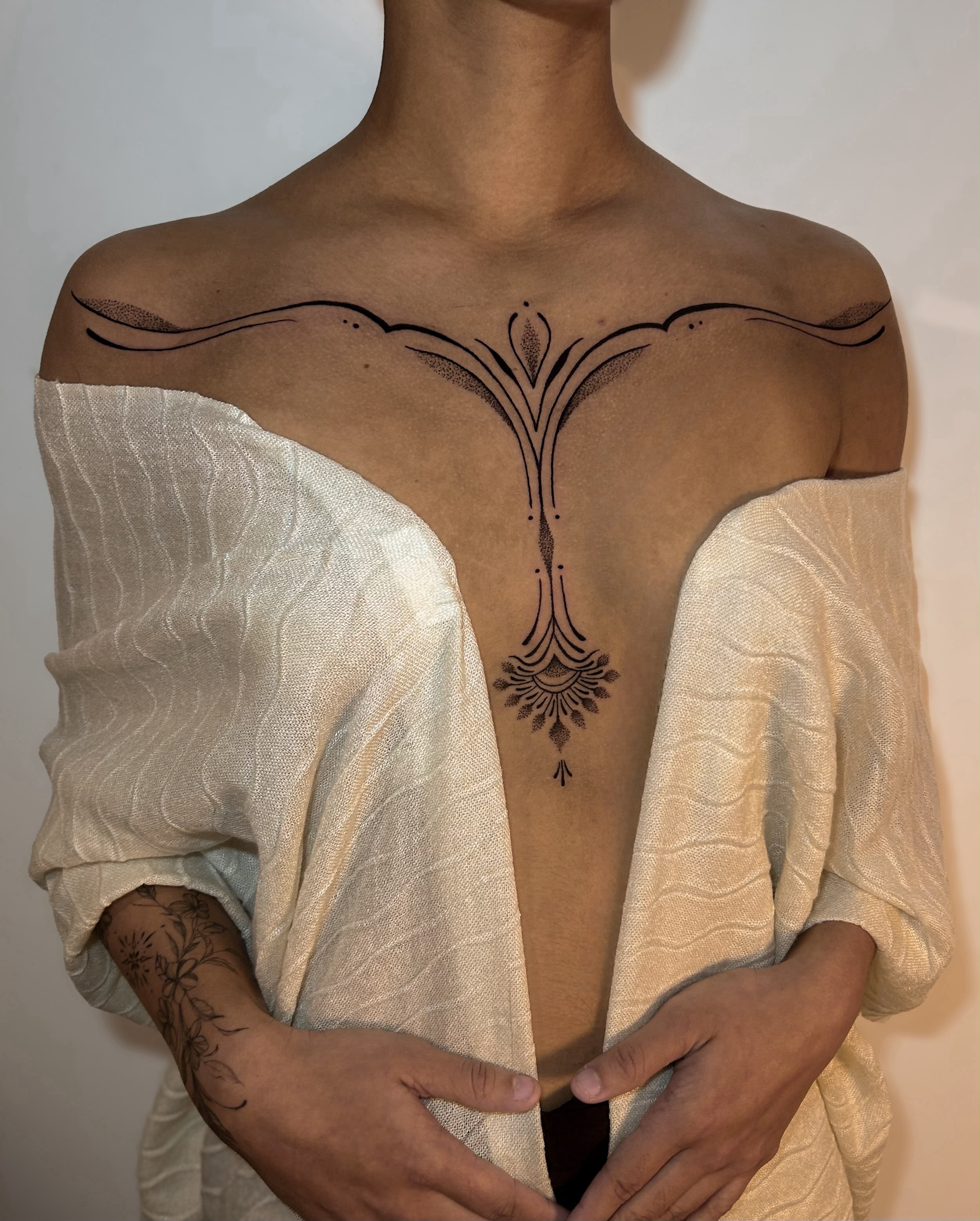 Esterno com tatuagem ornamental com linhas e medalhão central