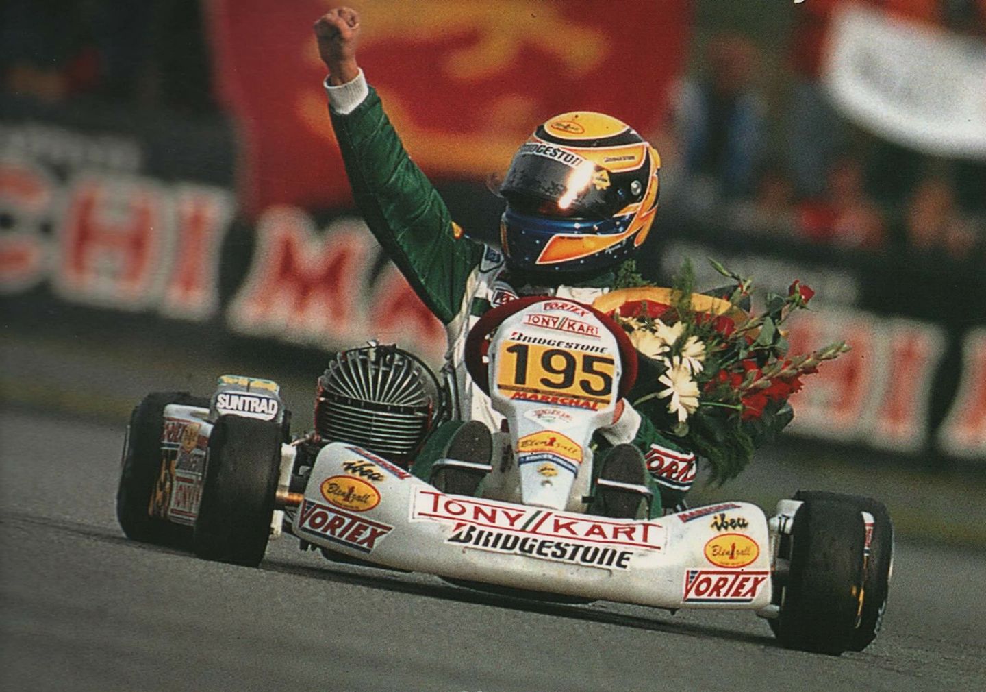 Victory celebration - driver with fist raised holding flowers