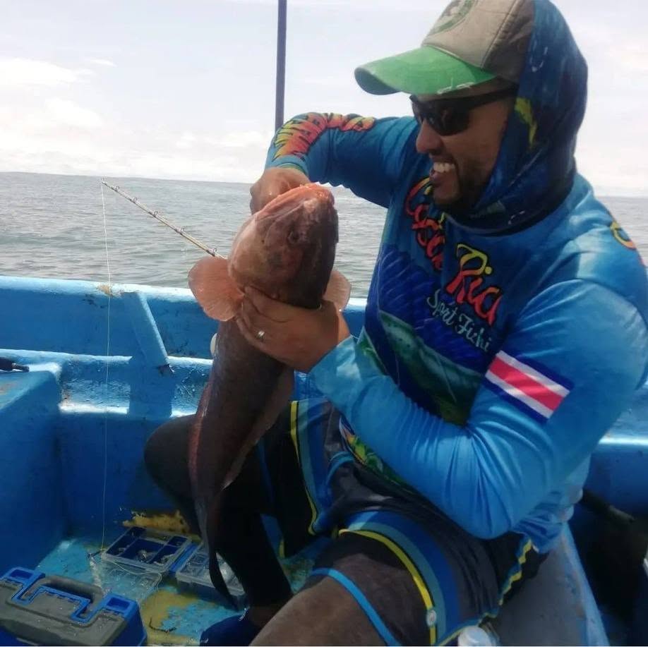 Pescador con una captura desde una lancha