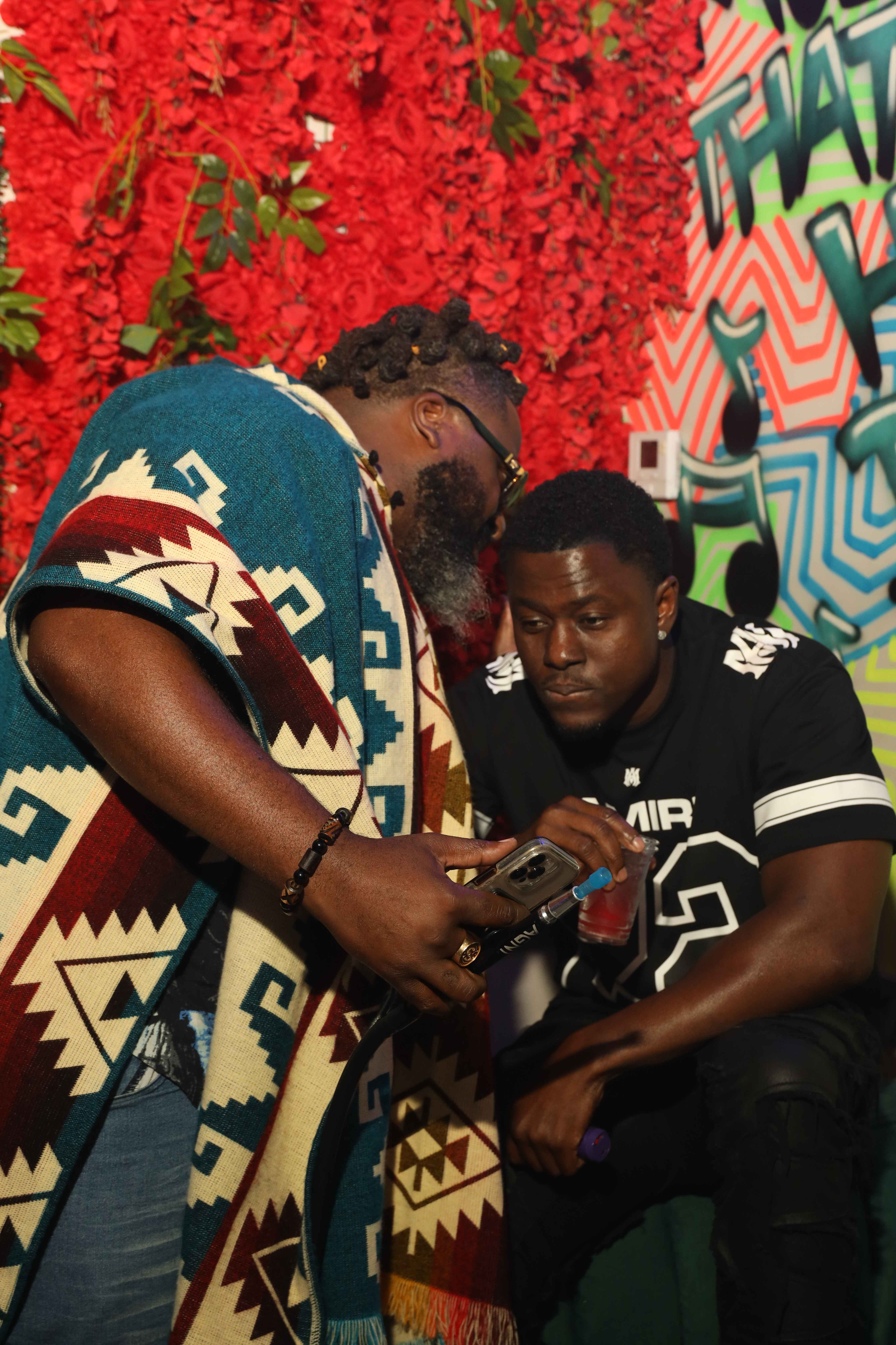 Friends sharing moment at red flower wall