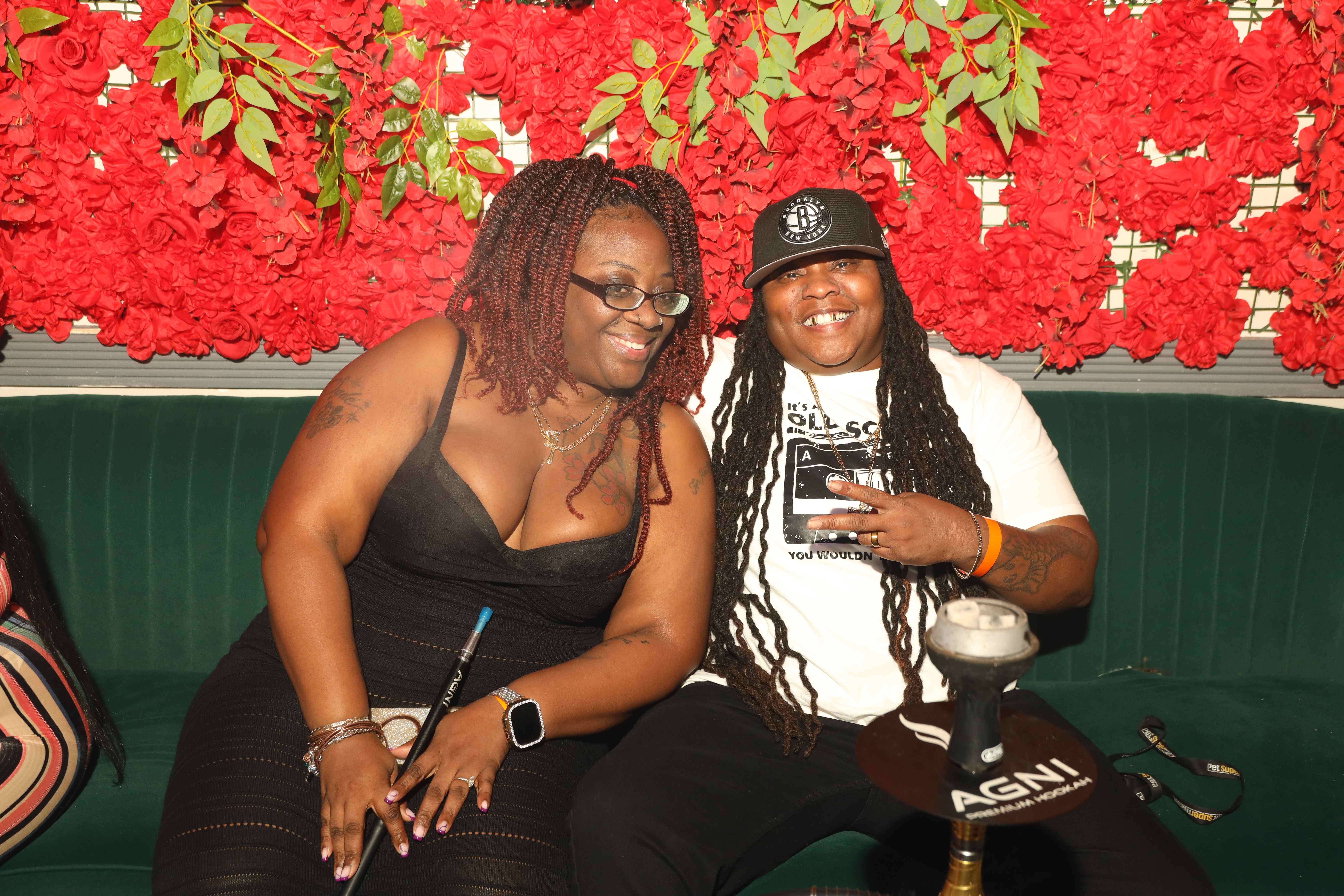 Friends enjoying hookah at red flower wall