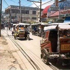 Belebte Stadtstraße mit Trishaws und Jeepneys