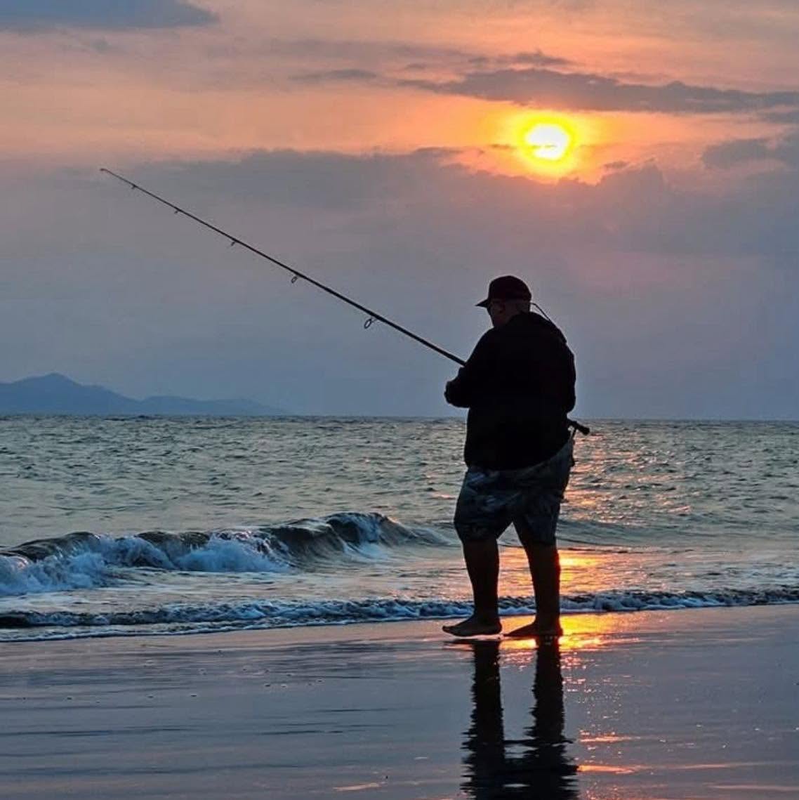 Pescador en la playa al atardecer