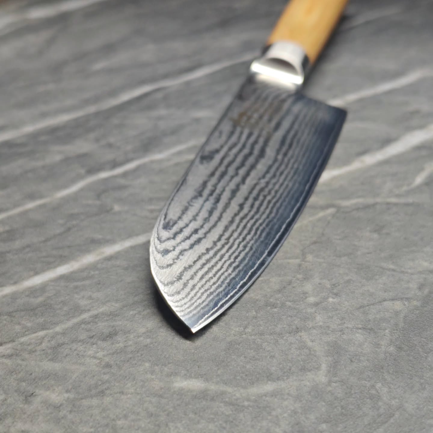 Sharpened Damascus chef knife with a polished edge after professional sharpening