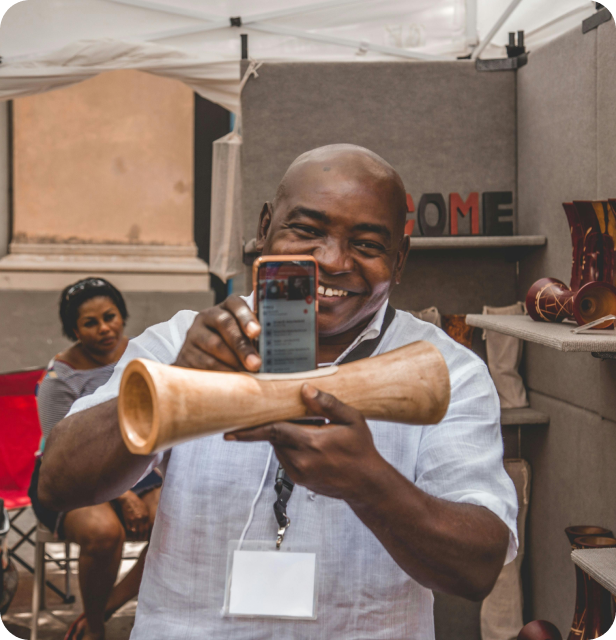 Enthusiastic African entrepreneur taking photo of traditional instrument