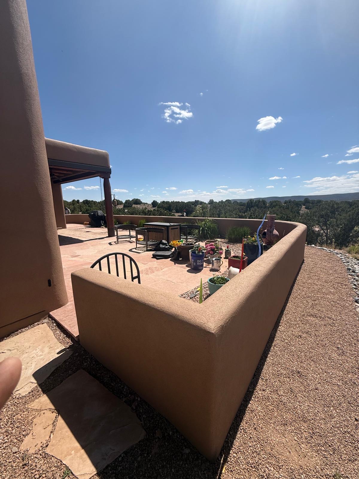 Outdoor patio with curved stucco wall enclosure and mountain views