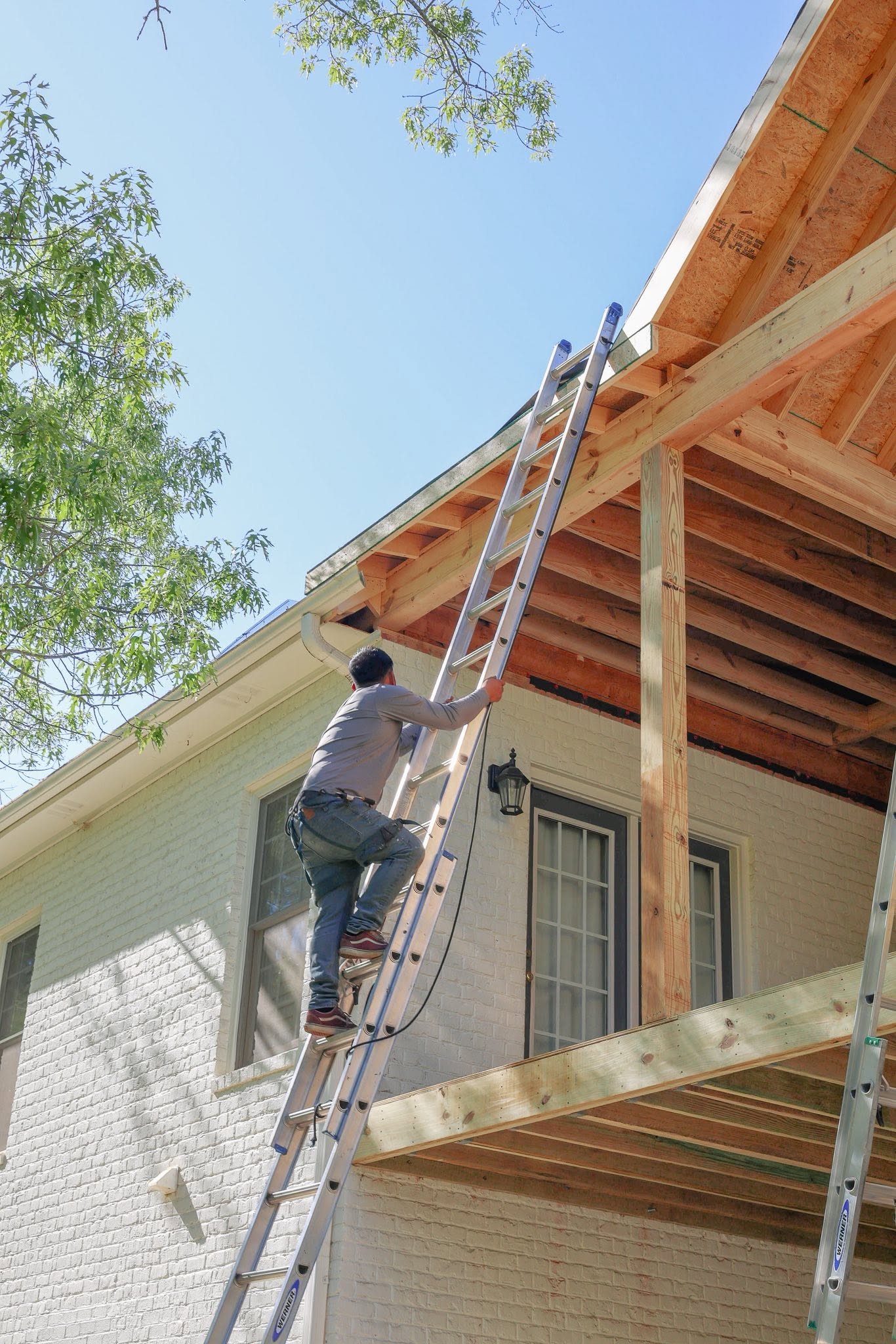 A Morse Trades craftsman working on a porch roof addition during construction