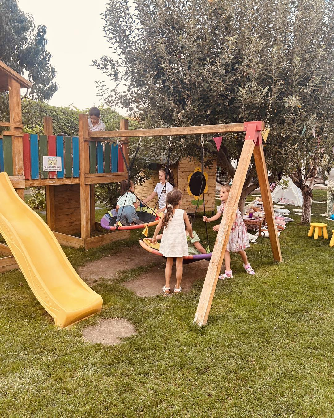 Masă aranjată pentru petrecere aniversară în grădina Kids Club cu piscina în fundal