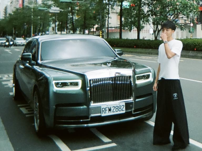 Guy flexing with Rolls Royce