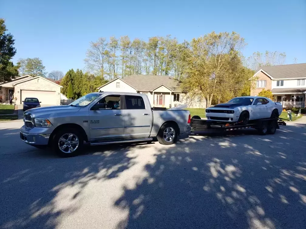 Ram truck towing a Dodge Challenger on the trailer