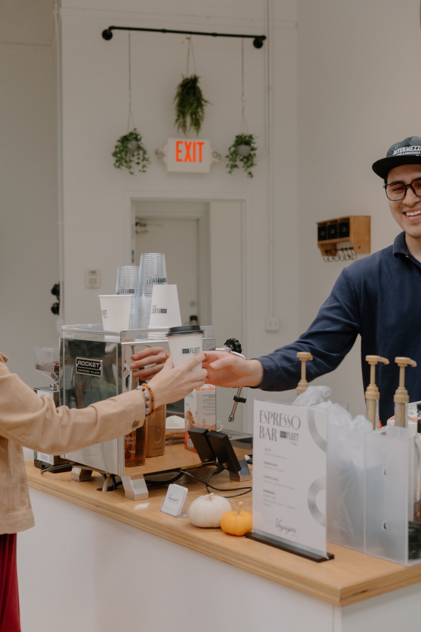 Friendly barista handing coffee to guest at espresso bar - Coffee cart service for events Omaha