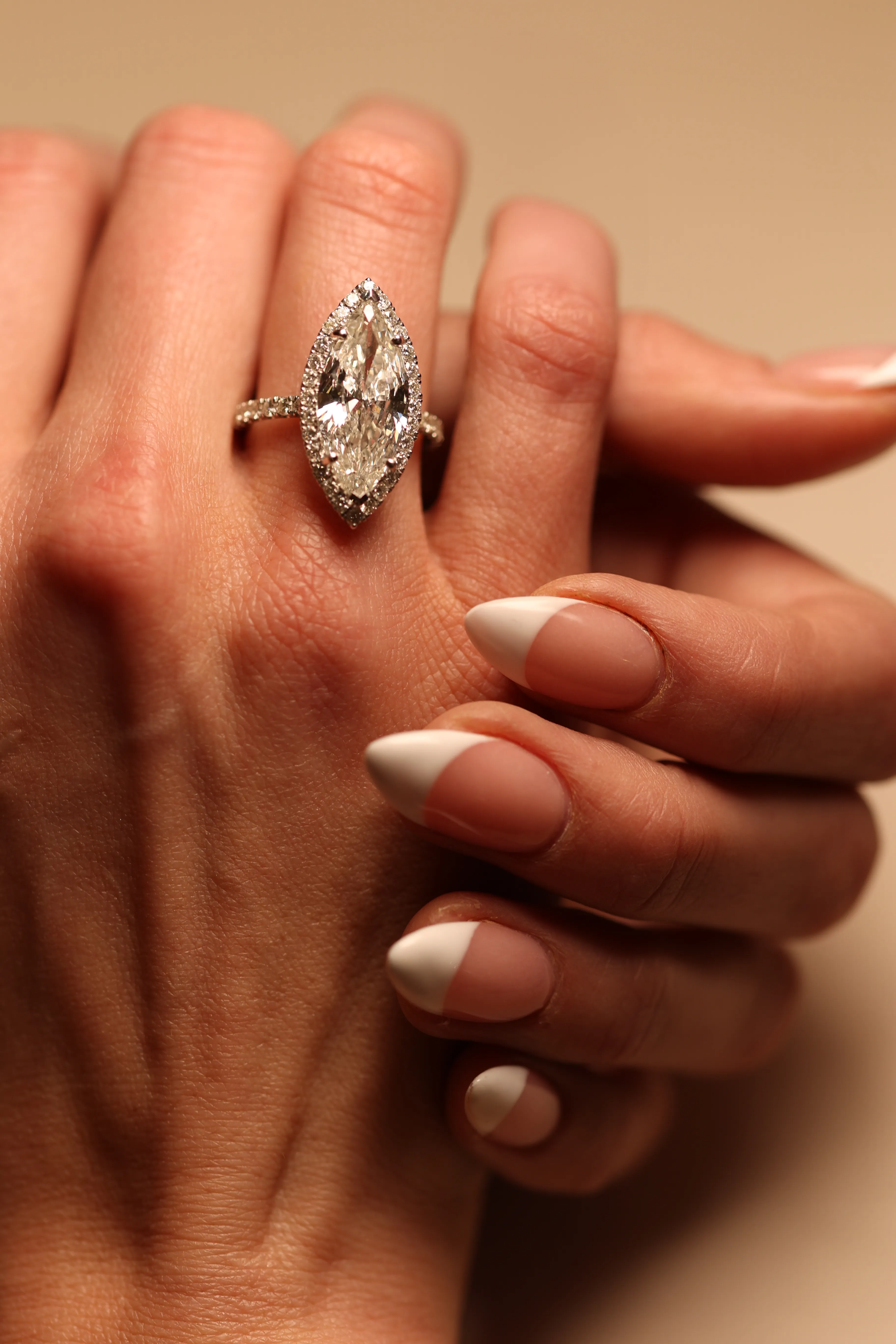 Close-up of marquise diamond ring with French manicure