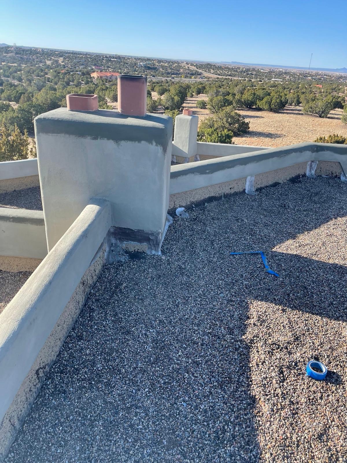 Rooftop parapet stucco work with chimneys and desert view