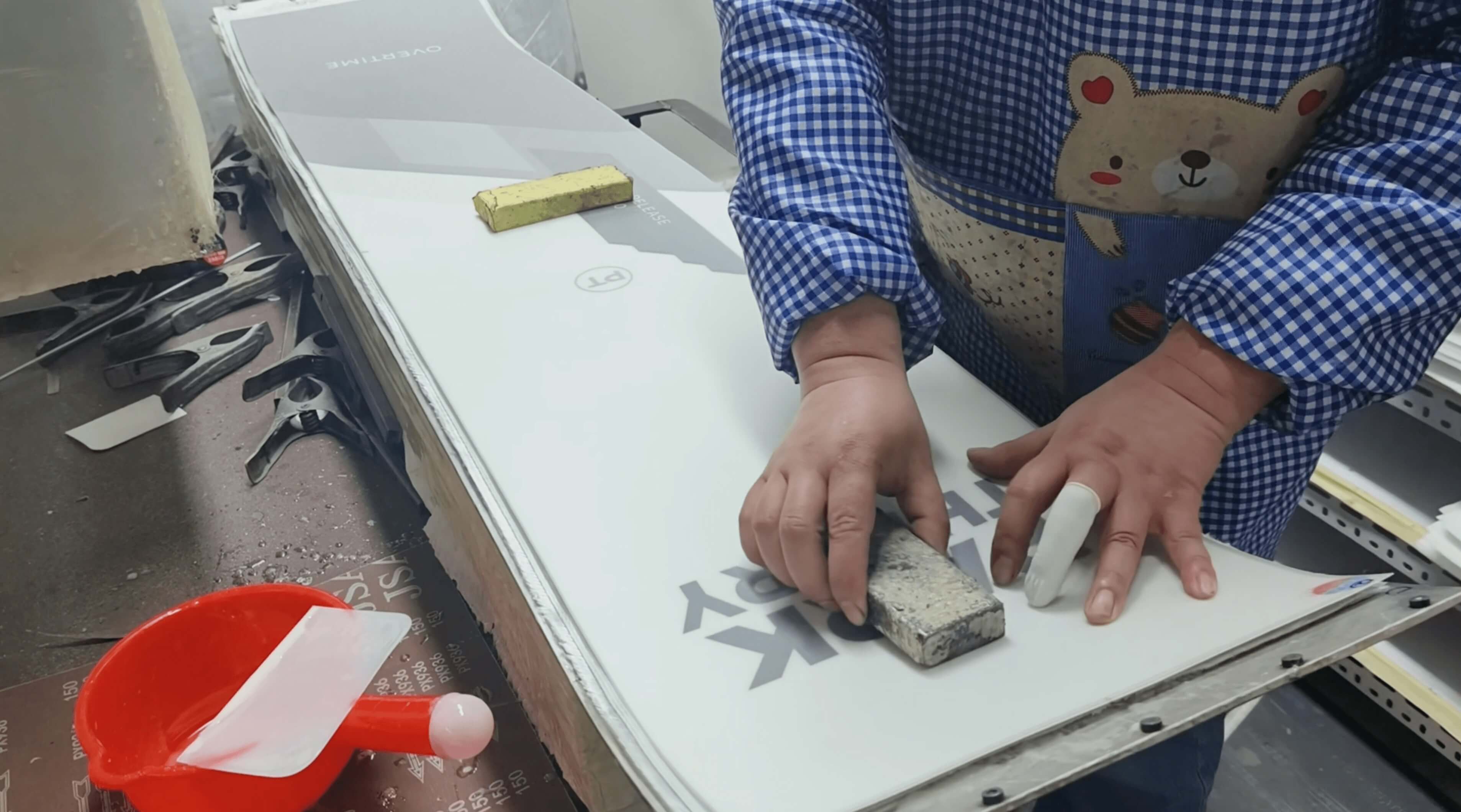 Printed topsheet being smoothed down onto the board assembly