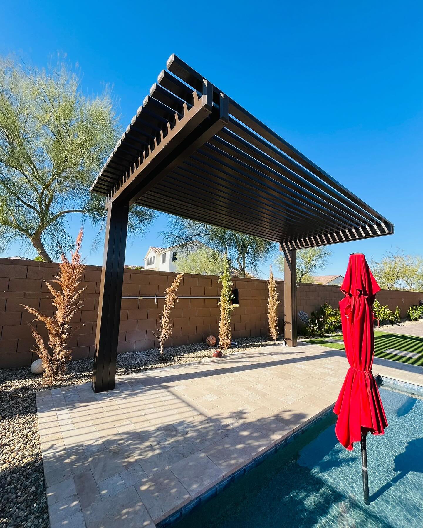 Cantilevered patio cover over a stone outdoor kitchen and bar