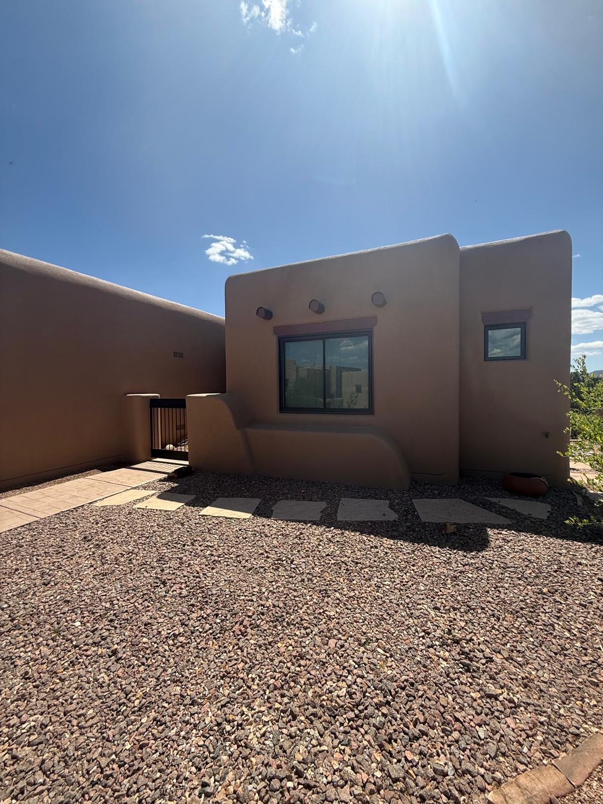 Completed adobe stucco home exterior with gravel landscaping