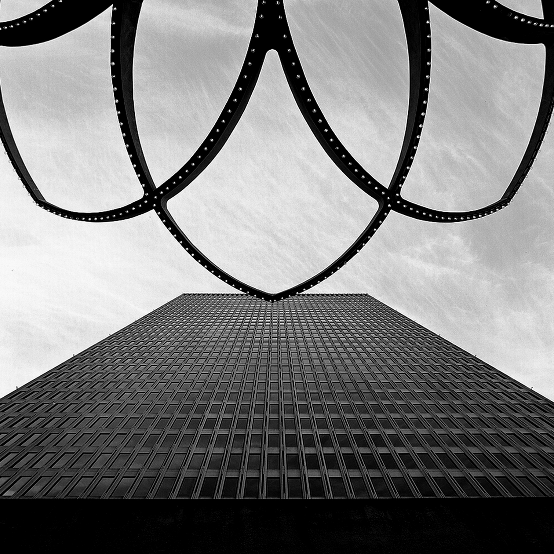 Monumental sculptural arches with riveted metalwork and grid floor pattern creating geometric composition