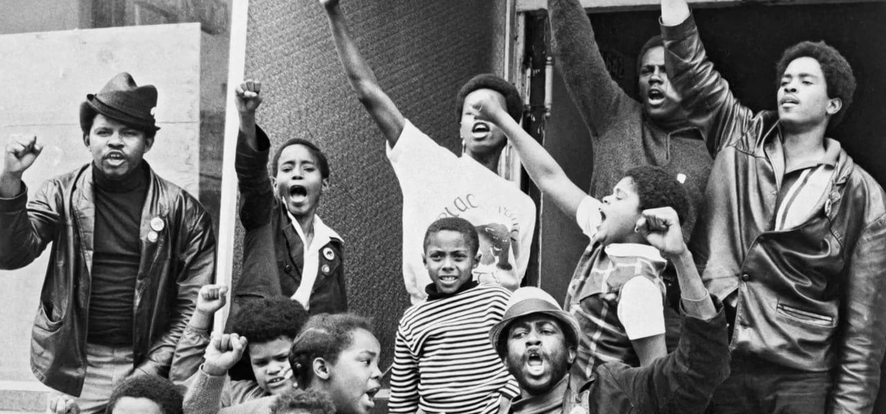 Black community members and children with raised fists